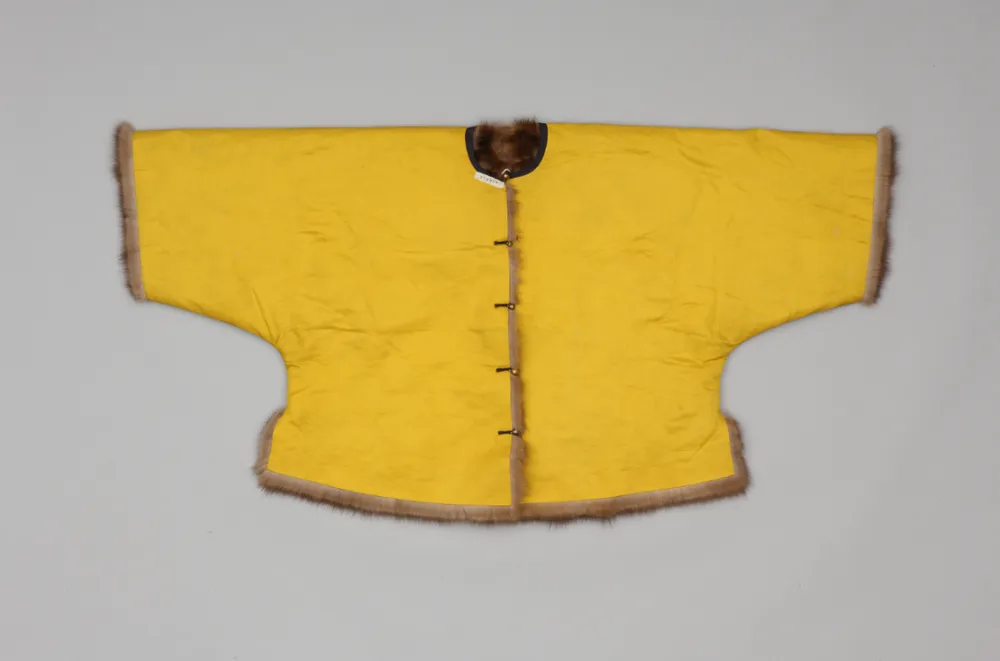 An imperial bright yellow woolen beige magua (riding jacket) lined with marten fur from the Qianlong period of the Qing Dynasty, laid flat against a gray background.