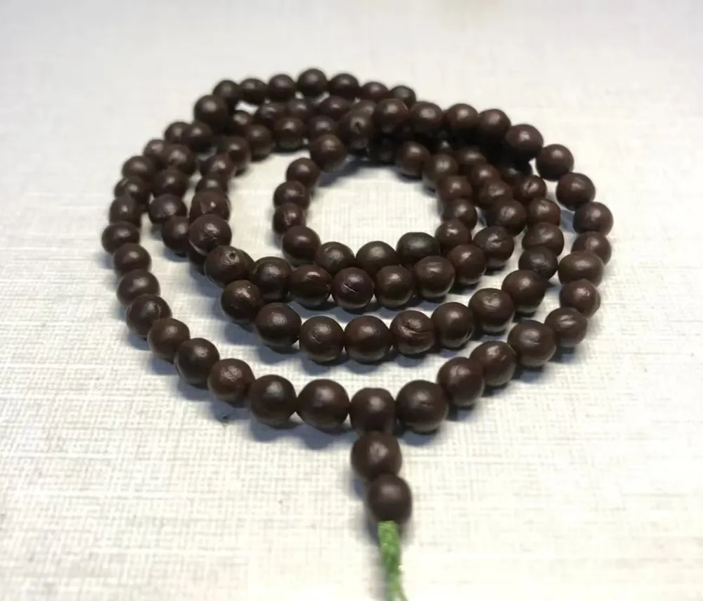 A traditional Buddhist prayer bead necklace Mala handcrafted from hard dark brown Goldenrain tree seeds