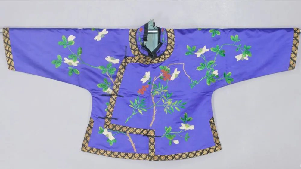 A blue satin lined Magua jacket from the Guangxu period of Qing Dynasty embroidered with white gardenia flowers and red nandina berries with beadwork